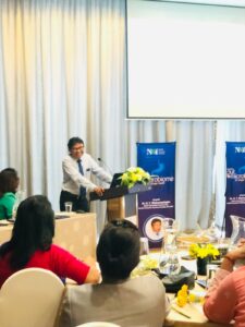 Speaker presenting at a professional conference session in Sri Lanka with delegates seated in a meeting room