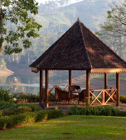 Luxury lakeside tea bungalow pavilion in Sri Lanka surrounded by lush greenery and hills