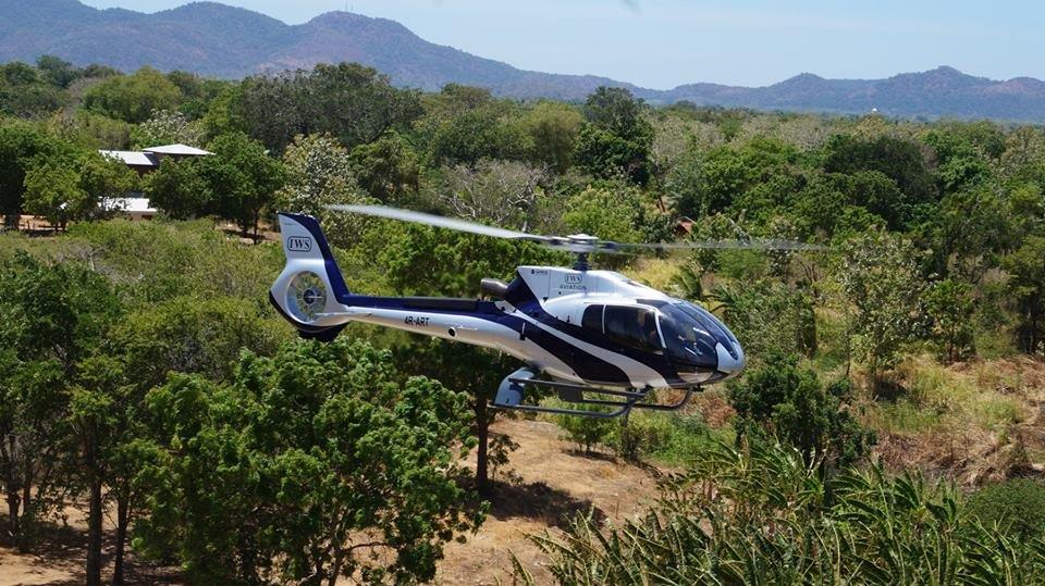 Private helicopter transfer flying over Sri Lanka coastline offering luxury aerial access to remote destinations
