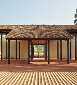 Luxury tropical resort entrance with palm trees and traditional Sri Lankan architecture at Amanwella